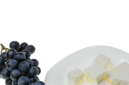 Close up view of black grape and brined white Feta cheese on white background. Healthy eating concept.の写真素材