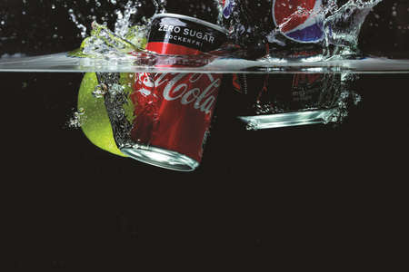 Close up view of two cans falling in water. Coca cola vs Pepsi cola. Sweden. Uppsala. 03.21.2021.のeditorial素材