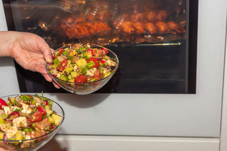 Close up view of woman making healthy green salad bowl.の写真素材
