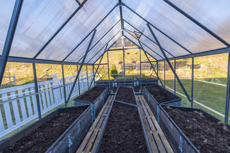 Ð¡lose-up view of prepared garden beds in a greenhouse for planting vegetables in early spring. Home gardening concept. Sweden.の写真素材
