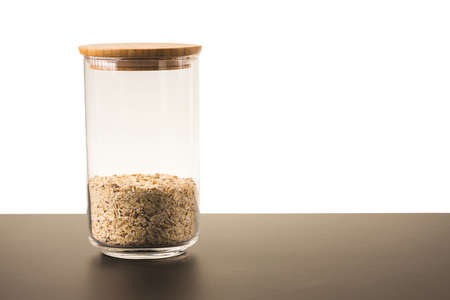 Close up view of glass jar with cereals oat isolated on white background. Kitchen and healthy food concept.の写真素材