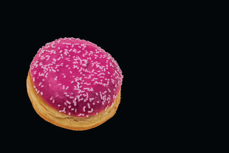 Close up view of pink donut sprinkled with white glaze isolated on black background. Food and drink concept.の写真素材