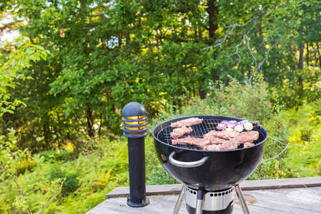 View of meat steak and red onion outdoors on on coal grill. Healthy food concept. Sweden.の写真素材