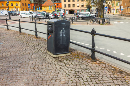 Beautiful view of metal waste container on cobblestone pavement of European city. Sweden. Uppsala. 05.18.2021.のeditorial素材