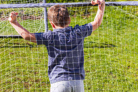 Close up view of young boy in football goal. Summer outdoor activities. Swedenの写真素材