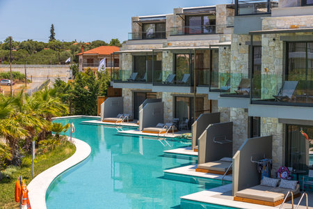 View of exterior of Portes Lithos Luxury Resort hotel building with swimming pool. Greece. Nea Potidaea. 07.18.2021.のeditorial素材