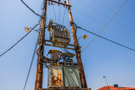 Close up view of old power line on blue sky background. Greece.