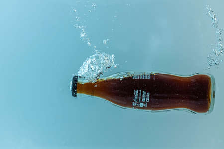 Close up view of Coca cola bottle falling in water. Sweden. Uppsala. 08.01.2021.のeditorial素材