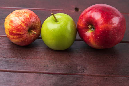 Close up view of ripe colorful apples isolated on wooden background. Organic vegetables concept.の写真素材