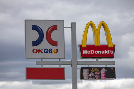 Close up view of logotype board of well-known gas station OKQ8 and McDonald's logotype board on...