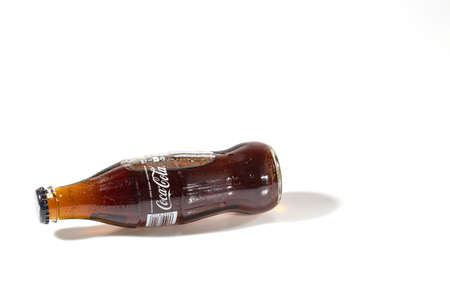Close up view of lying Coca Cola in glass bottle isolated on white background. Sweden. Uppsala. 09.28..2021.のeditorial素材