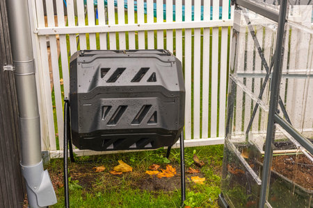 Close up view of black compost container near greenhouse. Environment concept. Sweden.