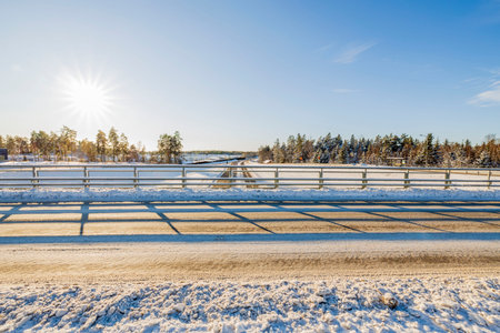 Beautiful view of with a bridge on a snowy highway on a background of blue sky. Sweden.の写真素材