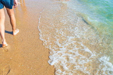 Beautiful  view of a man walking along sand beach  sea coast. Greece.