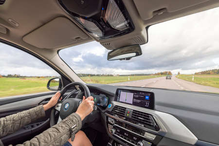 Close up interior view of BMWiX3 on road. Female driver in vehicle. Sweden. Uppsala. 10.24.2021.のeditorial素材