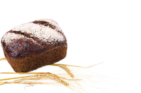 Beautiful view of whole grain loaf bread and spikelets of rye on white background isolated.の写真素材