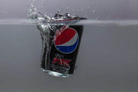 Close up view of can of Pepsi cola falling into water isolation on background. Sweden. Uppsala....