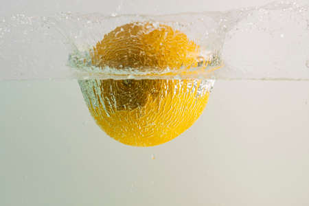 Beautiful view of melon falling into water on turquoise background. Gorgeous backgrounds.の写真素材