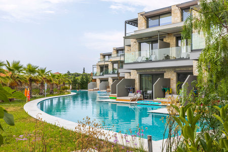 View of exterior of Portes Lithos Luxury Resort hotel building with swimming pool. Greece. Nea Potidaea. 03/09/2021.のeditorial素材