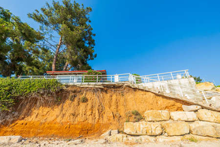 Beautiful view of house with white metal fence on cliff edge. Greece.の写真素材