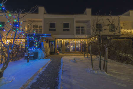 Beautiful exterior view of Christmas decorated townhouse on frosty winter evening. Sweden. Europe.の写真素材
