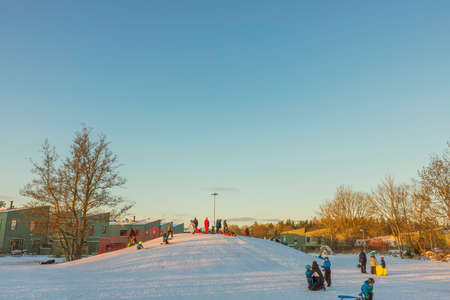 Beautiful view of people on outdoor playground on sunny cold winter day. Sweden. Uppsala. 12.25.2021.のeditorial素材