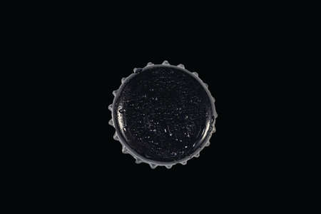 Top view of black metal cap with drops isolated on black background.の写真素材