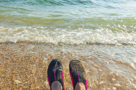 View of swimming shoes on feet of a man against background sea. Greece.の写真素材