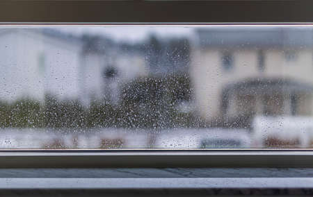 Blurred view of houses through wet rainy window. Sweden.の写真素材