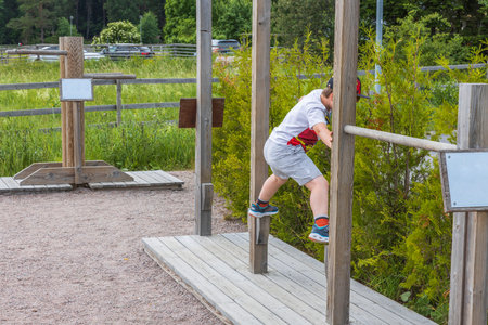 Beautiful view of child exercising in outdoor gym on sunny summer day. Sweden.