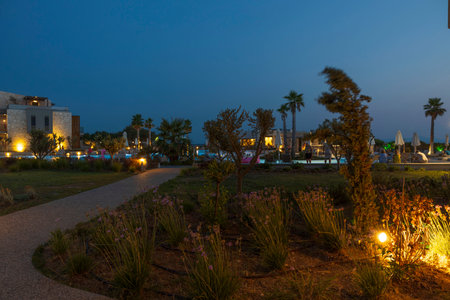 Beautiful night view of hotel area with tourists against backdrop of an outdoor pool. Greece. Nea Potidaea. 07.09.2021.のeditorial素材