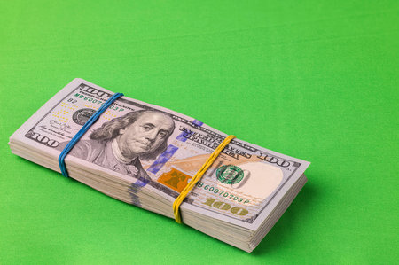 Close up of pack of 10,000 dollars isolated on green background.