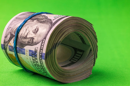 Close up view of 100 dollar bills rolled into roll isolated on chrome key background. Sweden.