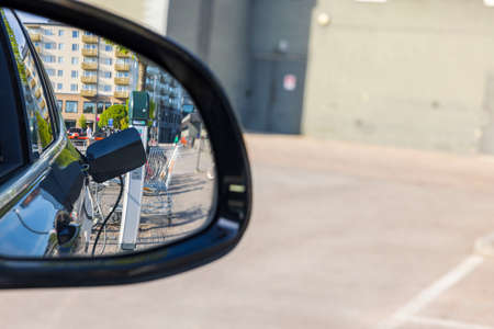 View in side mirror of electric car on connect charging cable. Sweden.の写真素材