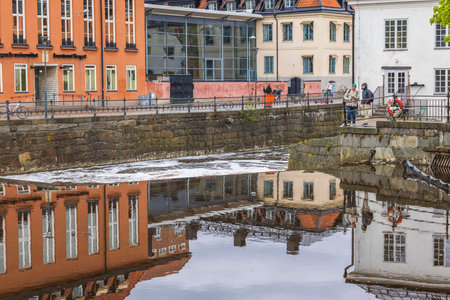 Beautiful view of two man on river coast on cold spring day in downtown Uppsala. Sweden. Europe....