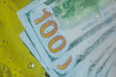Close up blurred view of hundred dollar bills under water. beautiful backgrounds.の写真素材
