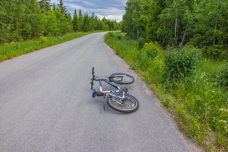 View of recumbent bicycle isolated on asphalt road with forest landscape in background. Sweden. uppsala. 06.29.2022.のeditorial素材