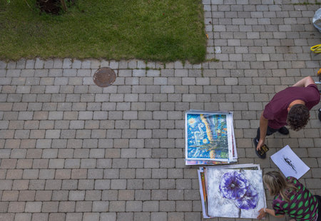 View of freelance painter selling his paintings to woman. Sweden.