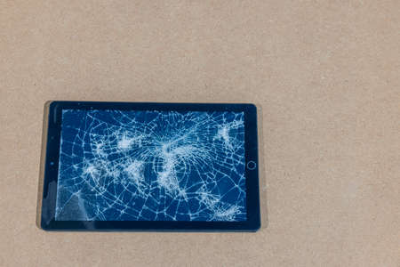 Close up view of electronic tablet with damaged screen isolated on gray background.の写真素材