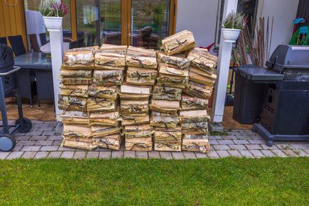 Close up view of birch firewood in transport nets on backyard of house. Sweden.の写真素材
