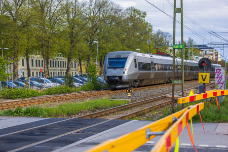 Beautiful view of speed electric train passing crossroad in town. uppsala. Sweden. Europe....