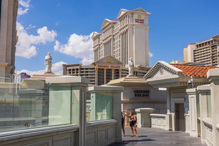 View of pedestrian bridge over Strip road and Caesars Palace hotel on blue sky background. Las Vegas, Nevada, USA. 09.16.2022.のeditorial素材