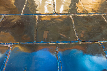 Close-up view of blue gold reflects on glossy floor tiles. colorful background.
