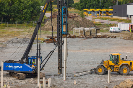 Industrial view on construction site. Pile driving machine driving piles into ground site. Sweden. enkoping. 08.05.2022のeditorial素材