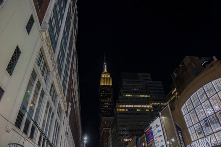 Beautiful backlit view of top of Empire State Building between skyscrapers night. New York City, Manhattan, USA. 09.22.2022.のeditorial素材