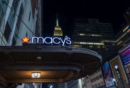 Breathtaking night view of exterior view of Macy's sign on wall of store on background from on Empire State Building between skyscrapers. New York, Manhattan, USA. 09.22.2022.のeditorial素材
