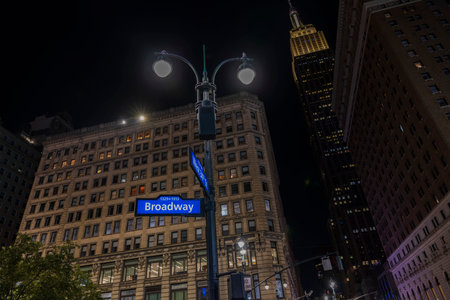 Beautiful night city view of tops of Empire State Building between buildings 34th Street and Broadway Street sign. new york. USA. 09.22.2022.のeditorial素材