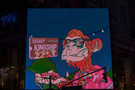 Close-up view of colorful image of mm's Kingship advertising on huge outdoor led display board in darkness. new york. USA. 09.22.2022.のeditorial素材