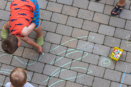 Top-down view from as children draws chalk on paving slabs. Sweden.の写真素材