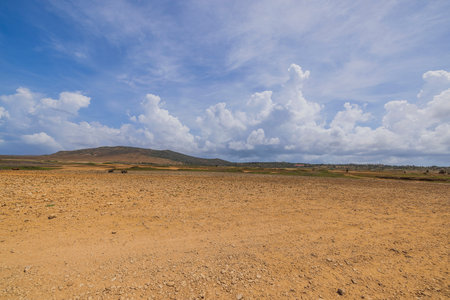 Beautiful view of stone desert of natural park on island of Aruba against backdrop of blue sky with white clouds.の写真素材